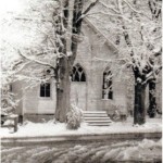 A church with snow on the ground and trees