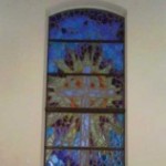 A stained glass window with the image of a tree.